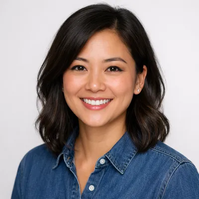 Professional headshot of a diverse adult with warm expression, studio background