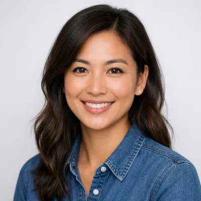 Professional avatar headshot of a diverse adult with a warm smile, wearing neat attire against a light gray background.