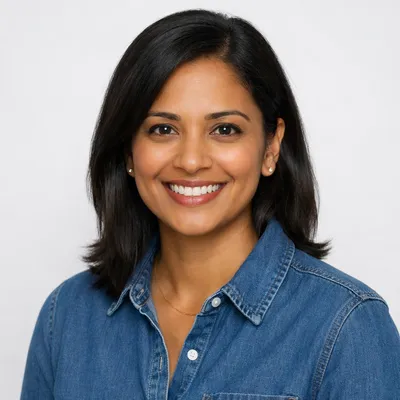 Diverse professional headshot of an adult with warm expression on light background
